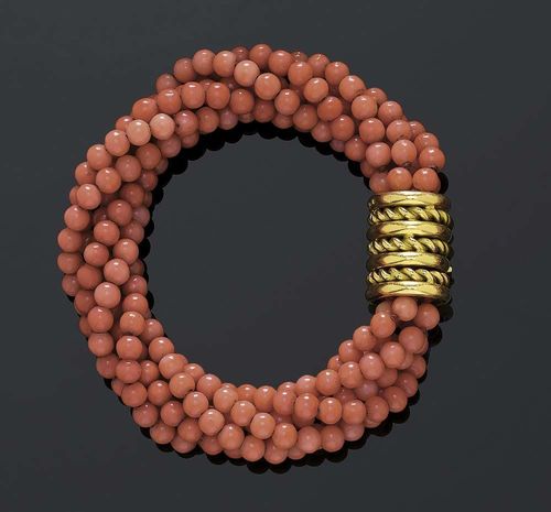 CORAL AND GOLD BRACELET, ca 1950. Yellow gold 750. Six-row bracelet consisting of salmon-rose coral beads of 5 mm Ø, cylindrical fastener with cordon and ring motifs. L ca. 22 cm.