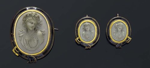 SET: LAVA CAMEO, AND ENAMEL BROOCH AND EARRINGS, ca 1860. Silver, gold-plated. Very decorative set, the brooch shows a lava cameo with a portrait bust in relief of a bachante, elegant, fine frame in the shape of a black enamelled, styled belt with buckle, the clasp additionally decorated with knurled gold wire. Matching pair of similar earrings. Slight traces of wear. With the original case.
