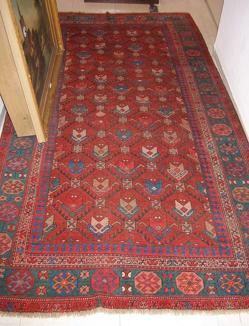 CAUCASIAN old. Rust coloured central field, honeycomb pattern with stylized flowers, blue border, slight wear, 210x112 cm.