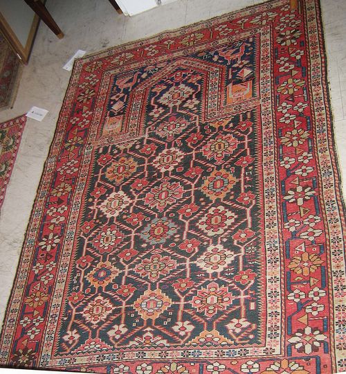 SHIRVAN old. Black mihrab with colourful flowers, blue spandrels with depictions of animals, red border with stylized flowers, signs of wear, 152x117 cm.