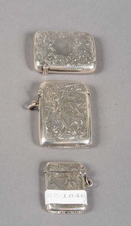 THREE SILVER MATCH BOXES, Birmingham, 1901-1915. Maker's marks. Year stamp for 1905-06, 1912-13, and 1914-15. Rectangular form with rounded side and hinged lids, engraved decoration and each with cartouche for engraving of monogram, one with initials 'JWM', two with eyelets for hanging, L 3.5 cm, 5 cm, 5.5 cm. One box dented.