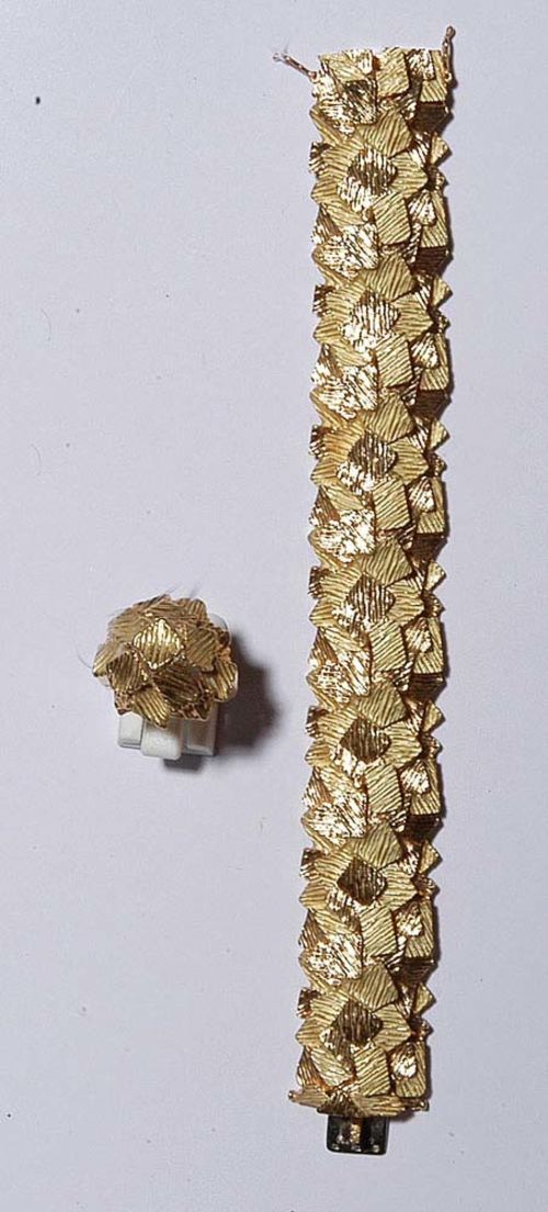 GOLD BRACELET GÜBELIN, WITH RING. Yellow gold 750. 71 g. Very fancy, slightly convex bracelet, the top consists of numerous stacked, rectangular platelets with a structured and partially matte-finished surface. L ca. 17.5 cm, W ca. 2.2 cm. - Matching assorted ring of similar design. Size 60.
