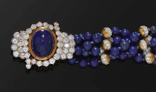 LAPIS-LAZULI AND DIAMOND BRACELET, ca. 1950. Yellow and white gold 750. Fancy five-row bracelet made of lapis-lazuli beads of ca. 5.9 mm Ø and small gold and diamond beads as links totalling ca. 1.00 ct. The clasp is set with 1 lapis-lazuli cabochon, surrounded by 40 brilliant-cut diamonds totalling ca. 4.00 ct. L ca. 20 cm.
