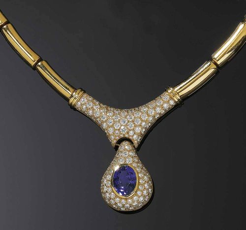 TANZANITE, BRILLIANT-CUT DIAMOND AND GOLD NECKLACE. Yellow gold 750. Attractive, casual-elegant necklace with slightly convex semi-cylindrical chain links. The top is set with numerous brilliant-cut diamonds; the drop-shaped, movably mounted pendant is set with numerous brilliant-cut diamonds and adorned with 1 oval tanzanite of ca. 6.10 ct. Total weight of the brilliant-cut diamonds 6.20 ct. L ca. 41.5 cm