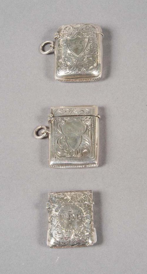THREE SILVER MATCH BOXES, Chester, 1885-1915. Maker's marks and year stamps for 1885-86, 1901-02, and 1914-15. Engraved with trailing leaves, each with a cartouche for monogram, one with the initials 'ADG', eyelets for hanging. L 4.3 cm.