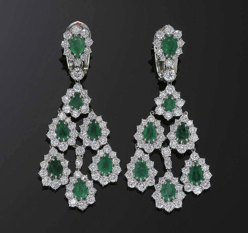 EMERALD AND DIAMOND PENDANT EARRINGS. White gold 750. Very elegant, attractive pendant earrings, the clip parts set with 1 emerald drop each, in a brilliant-cut diamond surround with a larger brilliant-cut diamond at the end, and 6 emerald drops on a movable mount underneath, each in a brilliant-cut diamond surround. Total weight of the emeralds ca. 6.80 ct, total weight of the 140 brilliant-cut diamonds and 2 navette-cut diamonds ca. 9.50 ct. L ca. 6.8 cm.