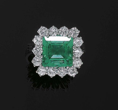 EMERALD AND BRILLIANT-CUT DIAMOND RING. White gold 750. Very elegant, classic ring, the square top is set with 1 rectangular Columbian emerald of ca. 6.20 ct, surrounded by 14 brilliant-cut diamonds totalling ca. 2.40 ct and of fine quality. Size 59-61. With SSEF Report No. 47297, moderately enhanced by oil, September 2006.