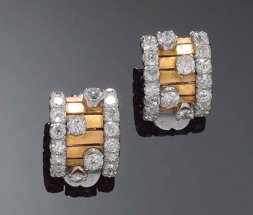 PAIR OF DIAMOND AND GOLD EARCLIPS, circa 1940. Yellow and white gold ca. 500. Front of lamella design, flanked by 2 diamond lines of 32 old mine-cut diamonds totalling ca. 2.00 ct, further enhanced with 8 diamonds totalling ca. 1.20 ct.