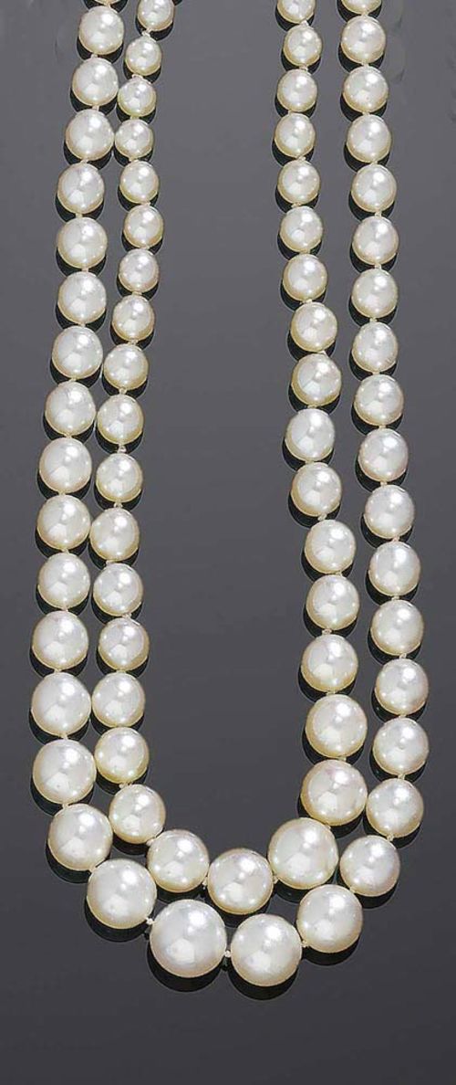 LOT OF TWO PEARL AND DIAMOND SAUTOIRS, ca. 1920. White gold fastener. Sautoir of 168 graduated natural pearls of 2-6.5 mm Ø and of fine quality. Later oval fastener set with 1 navette-cut diamond of ca. 0.20 ct surrounded by 10 brilliant-cut diamonds totalling ca. 0.30 ct. L 60 cm. Comes with an endless sautoir of 259 graduated natural pearls of 2.7-7 mm Ø and of fine quality. L ca. 95 cm.