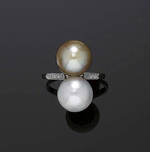 PEARL AND DIAMOND RING, France, ca. 1910. Platinum. Elegant ring, the top is set with a white and olive-green, slightly button-shaped natural pearl of 10.4 and 10.8 mm Ø respectively. The ring shoulders are decorated with 8 small diamonds. Size 54. Matches the previous lot. With SSEF certificate.