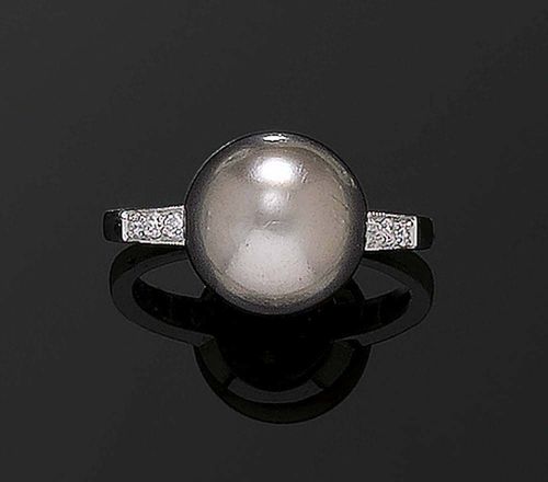 PEARL AND BRILLIANT-CUT DIAMOND RING, ca. 1950. Platinum. Attractive, classic ring, set with one button-shaped gray-brown natural pearl measuring 10.91 x 10.96 x 7.39 mm, 6.701 ct, flanked by 6 brilliant-cut diamonds totalling ca. 0.06 ct. Size ca. 51. -With SSEF Report No. 22535, 25 April 1990. -Copy of the insurance estimate of 11 April 2002.