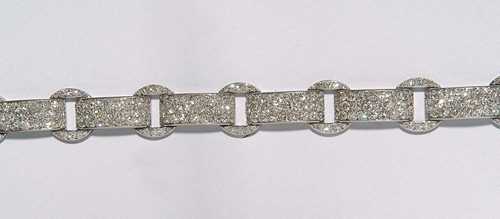 DIAMOND AND ENAMEL BRACELET, CARTIER Paris, ca 1930. Platinum. Fancy bracelet, the rectangular slightly convex links are connected by intermediary diamond-set rings, the sides of each link are black enamelled. Total weight of the ca. 293 brilliant-cut diamonds ca. 8.00 ct, signed Cartier Paris No. 07562. The clasp has a later added eyelet. Enamel on the intermediary rings partially damaged, L ca. 17.4 cm. -From a private collection. -Auction Christie's New York 1993, Lot 256.