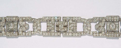 DIAMOND BRACELET, ca. 1935. Platinum. Attractive bracelet consisting of four open-worked, ornamentally decorated, oval links. The top is completely set with 4 larger old-mine-cut diamonds totalling ca 1.40 ct, 328 small old-mine-cut diamonds totalling ca 13.00 ct and 24 diamond baguettes totalling ca. 1.00 ct. L ca. 19 cm. W 1.8 cm.
