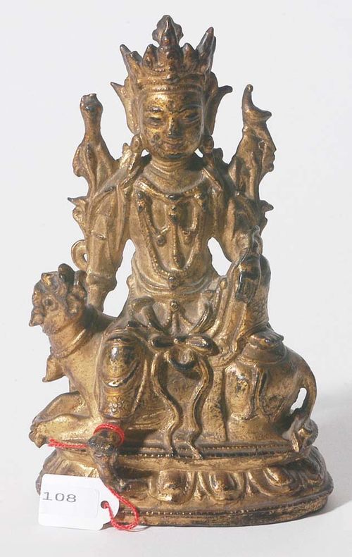 BODHISATTVA ON A LION.China, Ming Dynasty, H 17 cm. Bronze with gold over black lacquer. The crowned and richly decorated Bodhisattva is seated on the mythical lion in a relaxed rajalilasana posture. Two lotus flowers are growing next to his shoulders. There is a pigeon sitting on his left shoulder.