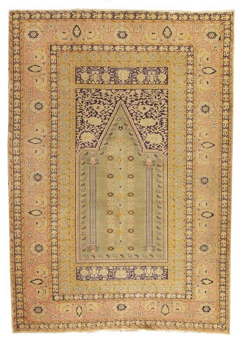 GHIORDES antique. Light green mihrab with tree of life and dark spandrels, broad stepped border in pink with stylised floral motifs. Slight wear.180 x 125 cm.