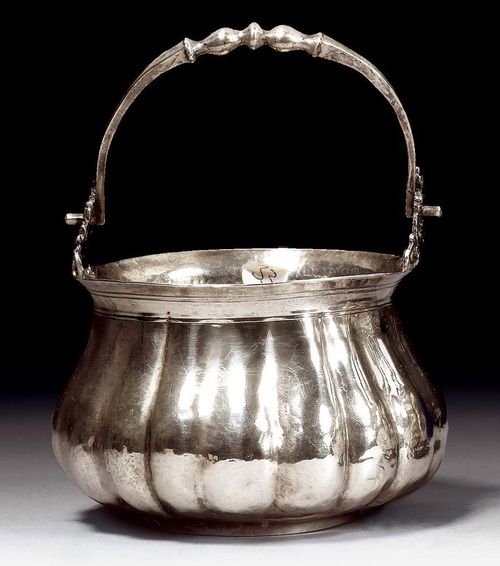 INCENSE BURNER. Veneto, 18th century.Maker's mark. Slightly curved form with regularly chased vertical folds. Rim and base with engraved moulding. On both sides: open-worked holders with animal heads for receiving the simple handle. 8x12 cm. 180 g. Formerly part of the Bulgari Collection.