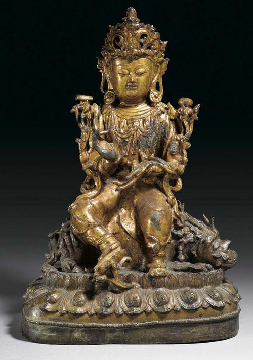 GUANYIN ON LION. Bronze with later reddish gilding.  The Boddhisatva's hands are raised in the gesture of teaching. Lotus mount. China, Ming Dynasty, H 39 cm.