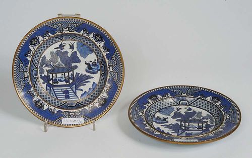 PAIR OF CLOISONNE PLATES with fine decorations in blue, black and white. Three scholars are expecting a guest in a pavilion surrounded by trees. In the background, two other scholars are seated on a stone slab and holding a discussion. Lotus tendrils on a light-blue background adorn the underside of the plates. China, 19th century. D 17.8 cm. (2). Berti Aschmann Collection.