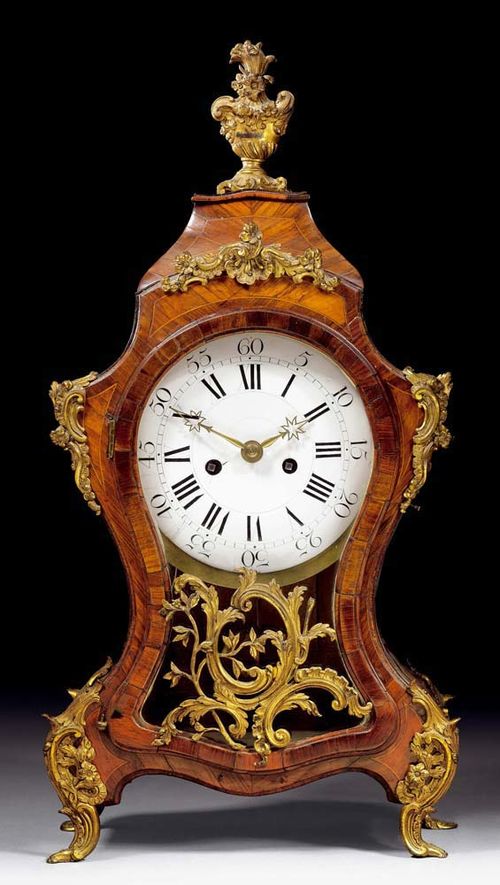 CLOCK,Louis XV, probably German, 18th century Tulipwood finely inlaid with light-coloured reserves and fillets. The case glazed on three sides. With bombé dial and 2 fine star-shaped hands. Verge escapement with 1/2 hour striking on bell. Gilt bronze mounts in the form of flowers and cartouches.  31x17x65 cm. Provenance: private collection, Germany.