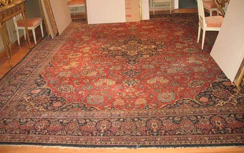 KESHAN old.Red ground with blue central medallion, patterned with trailing flowers and palmettes. Blue border. Slight wear. 458x350 cm.