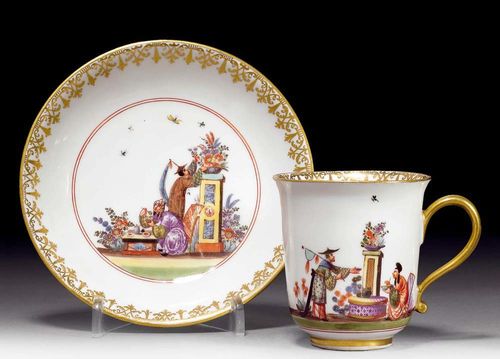 CHINOISERIE-DECORATED CUP AND SAUCER, Meissen, circa 1735-40.Depiction of tea preparation within a chinoiserie band in double ring border. Underglaze blue sword mark, Gold number 51, impressed number 5 on saucer, H cup 7cm. Provenance: from a private collection, Solothurn