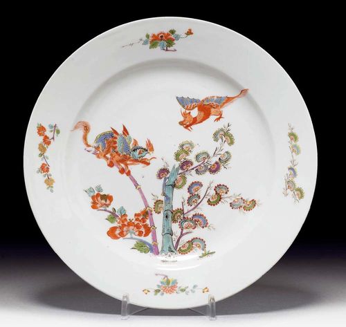 RARE PLATE WITH DRAGON MOTIF, Meissen, circa 1732-35.Painted in iron red, sea green, purple and green. With two dragons over a bamboo stem flanked by flowering branches. Underglaze blue sword mark, traces of a potter's mark oo for Johann Gottlieb Kühnel. D 21.3 cm. Minor rubbing. Provenance: from a private collection, Solothurn
