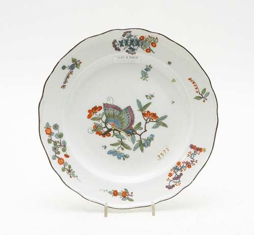 PLATE WITH BUTTERFLY DECORATION, Meissen, circa 1740.Painted in Famille Verte style with brown edging line. Underglaze blue sword mark, impressed number 19. D 23.5cm. Slightly chipped. Provenance: from a private collection, Solothurn