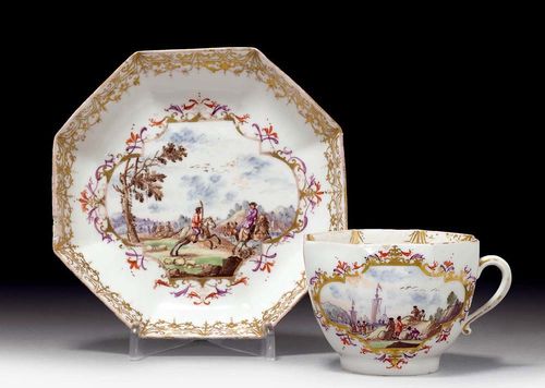 CUP AND SAUCER, Meissen, circa 1735-40.Painted with hunting and merchant scenes in four-sided gold cartouches with foliate work and bands in iron red and purple. The rims with gold lace border. Underglaze blue sword mark, potter's mark //, gilder's mark D. Heavily rubbed, with hair crack and repaired chip on the saucer. Provenance: from a private collection, Solothurn