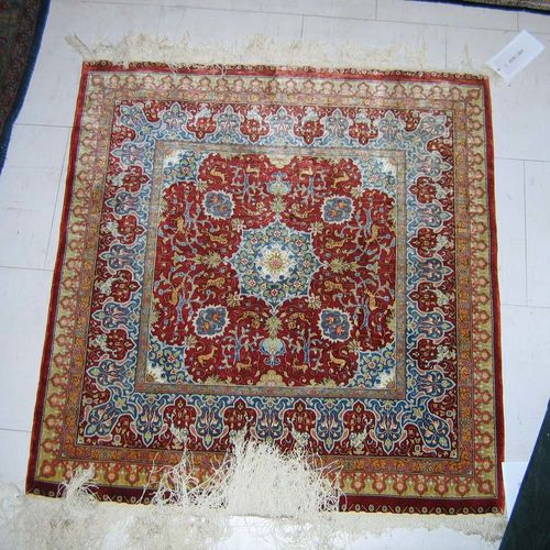 HEREKE silk. Red central field with blue central medallion, finely decorated with plants and animals. Good condition.  88x83 cm.