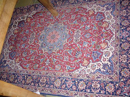ISFAHAN. Red ground with blue central medallion and white corners, decorated with trailing flowers and palmettes and blue border. Good condition. 170x120 cm.