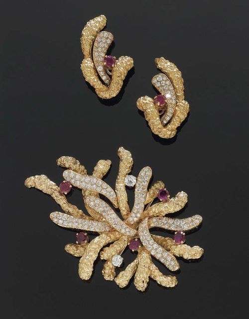 RUBY, DIAMOND AND GOLD BROOCH WITH CLIP EARRINGS, G. BILBAULT PARIS, circa 1950. Yellow gold 750. The leaves set with 150 brilliant-cut diamonds, the petals with 5 rubies and 2 old cut diamonds totalling ca. 0.80 ct. Also matching clip earrings with 2 rubies and 45 brilliant-cut diamonds. Total weight of brilliant-cut diamonds ca. 5.50 ct, and of rubies ca. 3.80 ct. With case.