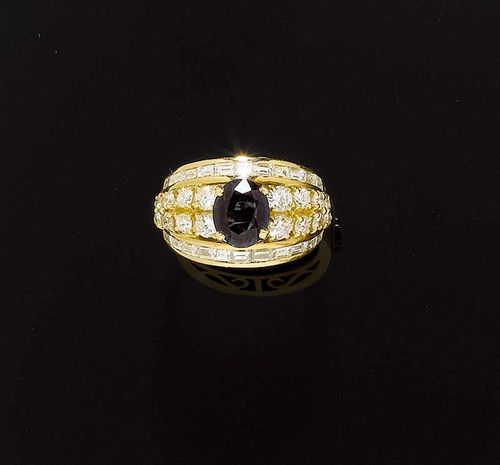 SAPPHIRE AND DIAMOND RING. Yellow gold 750. Decorated with 1 oval sapphire of ca. 1.80 ct, flanked by 18 brilliant-cut diamonds. The edges also set with 22 diamond baguettes. Total weight of brilliant-cut diamonds and diamonds ca. 2.50 ct. Size ca. 52.