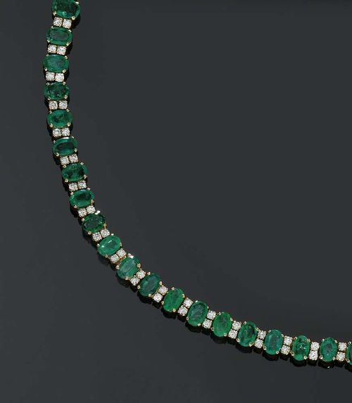 EMERALD AND BRILLIANT-CUT DIAMOND NECKLACE. Yellow gold 375. Classic Rivière necklace set with 62 graduated oval emeralds totalling ca. 20.50 ct, alternatingly set with 124 brilliant-cut diamonds totalling ca. 2.50 ct. L ca. 39 cm.