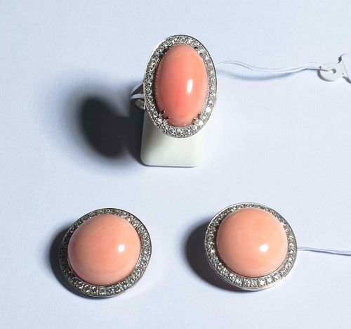 CORAL AND DIAMOND RING AND CLIP EARRINGS, E. MEISTER. White gold 750. Classic-elegant ring set with 1 light-pink coral cabochon of 20.6 x 12.6 mm, in a brilliant-cut diamond surround of ca. 0.30 ct. Size 57. Matching clip earrings, each with one round coral cabochon of ca. 17 mm Ø in a brilliant-cut diamond surround of ca. 0.60 ct. Matches the previous lot.