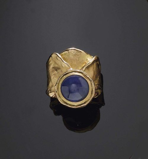 STAR SAPPHIRE AND GOLD RING. Yellow gold 750. With shaped surface, the top set with 1 blue Ceylon star sapphire cabochon of 12.72 ct and of fine quality. Size ca. 58. With an estimate and copy of the receipt, dated 1987 and 2004 respectively.