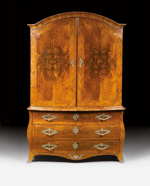 CABINET ON CHEST,Louis XV, by M. FUNK (Mathaus Funk, Murten 1697-1783 Bern), Bern circa 1740/50. Walnut and burlwood in veneer and molded. The lower drawer section with central bombe shaping, with 3 drawers, the top drawer being divided into two, the upper section with 3 drawers, gilt bronze mounts and sabots. 160x64x218 cm. Provenance: - Villa Rosenberg, Bern. - Swiss private collection.