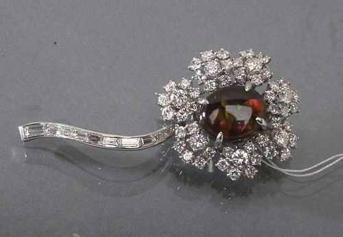 BRILLIANT-CUT DIAMOND AND FIRE AGATE BROOCH, ca. 1950. Platinum. Elegant flower brooch. The flowers decorated with 1 oval fire agate cabochon of ca. 12.2 x 10 mm, surrounded by 52 brilliant-cut diamonds. The stem is set with a row of 10 diamond baguettes. Total weight of the diamonds ca. 2.50 ct.