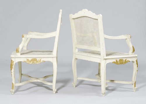 A PAIR OF PAINTED ARMCHAIRS, late Régence, France, 19th century. Carved wood painted white and with some gilding. Jonc seat and backrest. Painted decoration later.