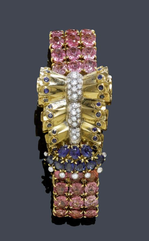 A GOLD AND GEMSTONE BRACELET UDALL & BALLOU, circa 1940. Yellow gold 750 and platinum. Elegant bracelet, the top with three sheaf motifs, the center set with 46 brilliant-cut diamonds flanked by an edging of 22 sapphires, ending with 9 oval sapphires and 7 brilliant-cut diamonds. The bracelet composed of 51 oval pink tourmalines in a classic setting. Total weight of the brilliant-cut diamonds ca. 1.50 ct, total weight of the sapphires ca. 3.50 ct and total weight of the tourmalines ca. 36.00 ct. L ca. 16,5 cm. Signed Udall & Ballou, from France. Udall & Ballou was founded in 1888 in New York was one of the finest jewelers in Manhattan. The firm was closed in 1949.