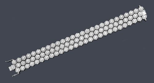 DIAMOND BRACELET. White gold 585. Elegant, modern bracelet of numerous, three-row rosette motifs, set throughout with a total of 567 brilliant-cut diamonds weighing ca. 13.60 ct. L 18 cm, W 1.8 cm. Matches the following lot.