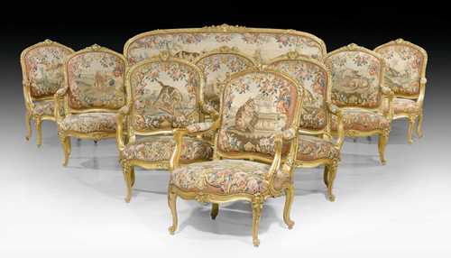 LARGE TAPESTRY SUITE OF FURNITURE,Louis XV, the covers from the Manufacture d'Aubusson, the later frames in the style of J.B. Tilliard (Jean-Baptiste I Tilliard, maitre 1738, or Jean-Baptiste II Tilliard, maitre 1752) or N. Q. FOLIOT (Nicolas-Quentin Foliot, maitre 1745), Paris, 18th/19th century. Comprising: 1 three-seater canape and 8 fauteuils "a la reine". Shaped and exceptionally finely carved gilt beech. Tapestry covers in excellent condition, with depictions from the fables of La Fontaine: including "Le taureau et la grenouille", "Le loup et la brebis", "Le chat et l'oiseau", "Le renard et le coq", "Le lion et les brebis", "L'aigle et la tortue", "Le renard et le cigogne". Canape 220x80x42x116 cm, Fauteuils 75x60x42x101 cm. Provenance: - From a Viennese collection. - Galerie Koller Zurich auction on 17.9.1997 (Lot No. 598).