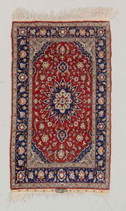 HEREKE SILK.Red ground with a central medallion, blue edging with trailing flowers, 63x103 cm.
