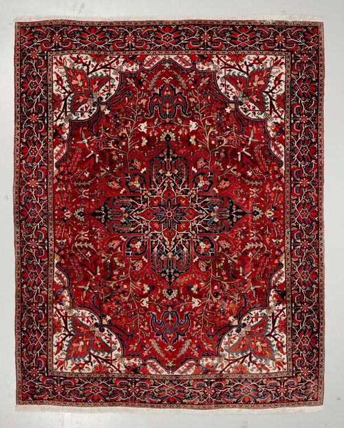 HERIZ old.Red ground with a central medallion and white corner motifs, patterned with trailing flowers and palmettes, black edging, 262x344 cm.