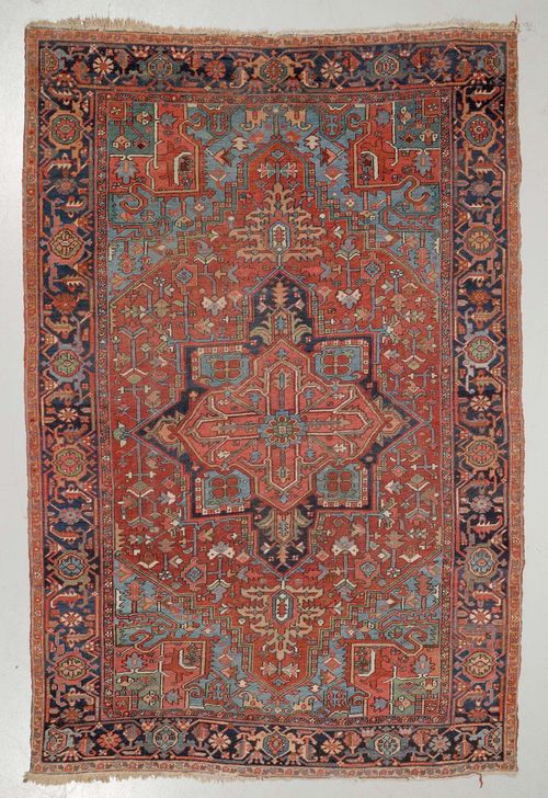 HERIZ antique.Red ground with a central medallion, typically patterned, dark blue edging, signs of wear, 215x320 cm.