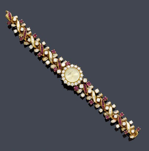 RUBY AND DIAMOND WRISTWATCH, VACHERON & CONSTANTIN, BRACELET RENÉ SIM LACAZE, Paris. Yellow gold 750. Fancy dress watch, the bracelet decorated with 16 round rubies and 35 carré-cut rubies weighing ca. 2.20 ct in total, as well as 28 brilliant-cut diamonds, 26 navette-cut diamonds, and 16 baguette-cut diamonds weighing ca. 6.00 ct in total. Round case No. 545108 P with crown on the back and lunette set with brilliant-cut diamonds weighing ca. 1.50 ct. Gold-coloured dial signed  Vacheron & Constantin, Genève. Mechanical movement No. 687341, Cal. 1430, signed. L ca. 16 cm. With case. Directly acquired from Lacaze in the 1970s.
