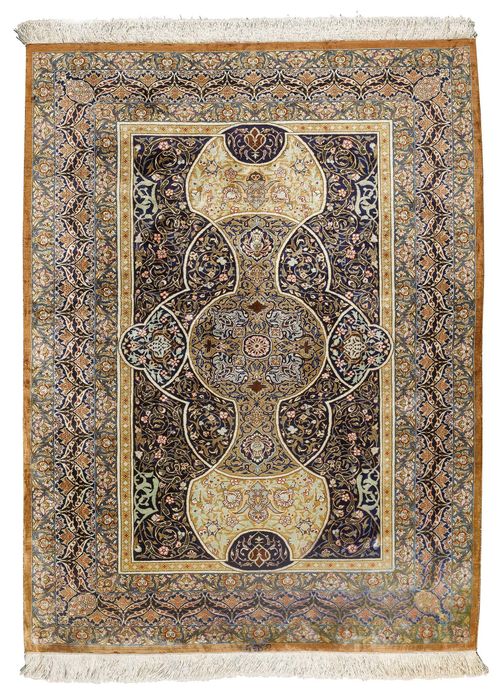 GHOM SILK.Dark central field with a central medallion, the entire carpet opulently decorated with colourful trailing flowers, 100x150 cm.