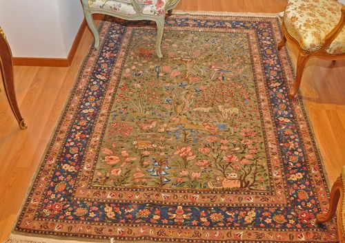 GHOM wool with silk.Green central field finely patterned with colourful plants and animals, blue edging, slight wear, 140x190 cm.