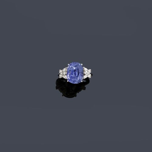 BURMA SAPPHIRE AND DIAMOND RING. White gold 750. Classic-elegant ring, the top set with 1 oval, light blue Burma sapphire of 10.22 ct, untreated, flanked by 4 navette-cut diamonds and 6 brilliant-cut diamonds weighing ca. 0.30 ct. Size 54. With AGGL Report No. 00535, January 2010.