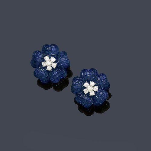 SAPPHIRE AND DIAMOND EAR CLIPS. White gold 750. Very attractive, elegant ear clips with a hinged stud, designed as sculptured flowers. Each with the centre set with 6 brilliant-cut diamonds, the petals set throughout with numerous fine square-cut sapphires, invisible setting. Total weight of the sapphires ca. 25.00 ct.  Total weight of the diamonds ca. 1.34 ct.