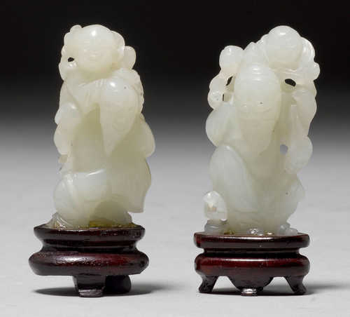 TWO CELADON JADE CARVINGS OF AN IMMORTAL WITH A BOY.